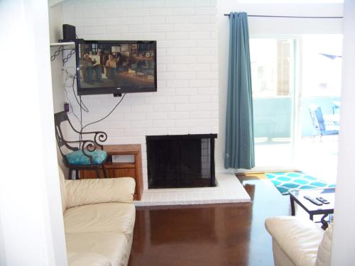 uma sala de estar com lareira e uma televisão na parede em Beach House em Newport Beach