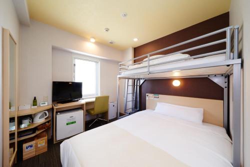 1 dormitorio con litera y escritorio en Super Hotel Osaka Tennoji, en Osaka
