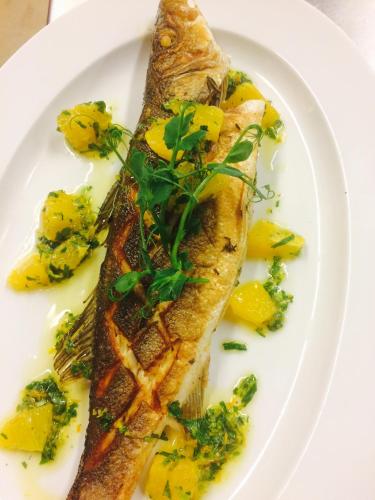 eine weiße Platte mit einem Stück Fisch mit Brokkoli in der Unterkunft Nice Private Room in Wien Center in Wien