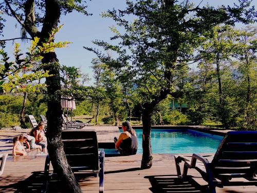 a group of people sitting around a swimming pool at Endemiko in Malalcahuello