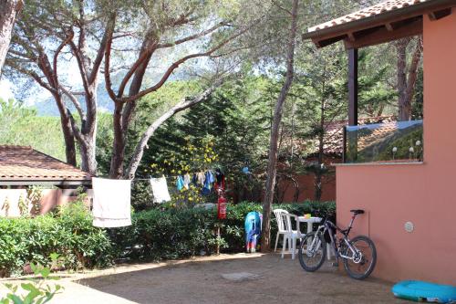 a bike parked next to a house with a clothes line at Camping Lacona Pineta in Capoliveri