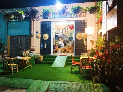 a room with chairs and tables and a green rug at Cao Bang Eco Homestay in Cao Bằng
