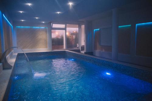 a large swimming pool with blue lights in a room at Petriti & Spa in Ulcinj