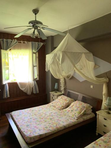 - une chambre avec un lit et un ventilateur de plafond dans l'établissement Matilona, à Sainte-Rose