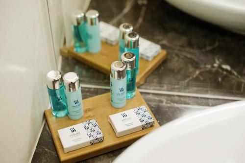 a bathroom with four bottles ofodorizers on a wooden shelf at Hotel Great Polonia Velvet Suwałki in Suwałki