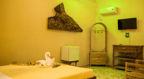 a room with two beds and a refrigerator and a mirror at Deep Forest Garden Hotel in Puerto Princesa City