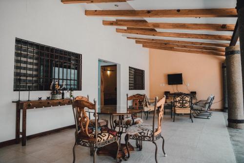 sala de estar con mesa, sillas y TV en Casa Teotitlán, en Oaxaca City