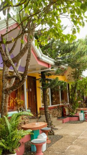 a building with a table and trees in front of it at Deep Forest Garden Hotel in Puerto Princesa City