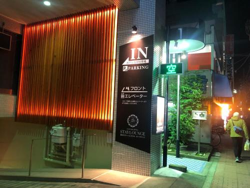 a building with a sign on the side of it at Nishikawaguchi Station Hotel Stay Lounge in Kawaguchi