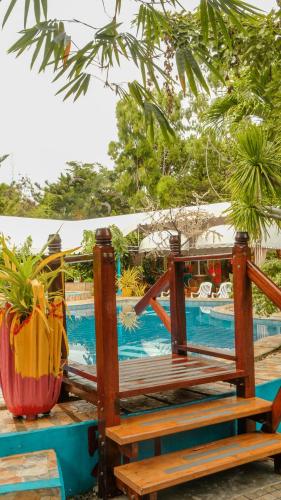 a wooden bench next to a swimming pool at Deep Forest Garden Hotel in Puerto Princesa City