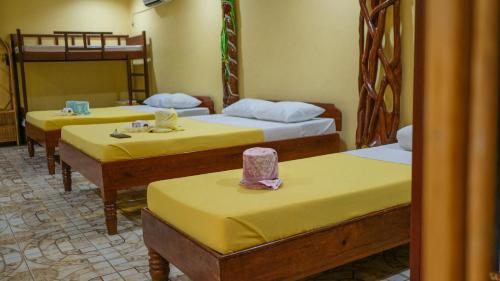 
a hotel room with two beds and a table at Deep Forest Garden Hotel in Puerto Princesa City
