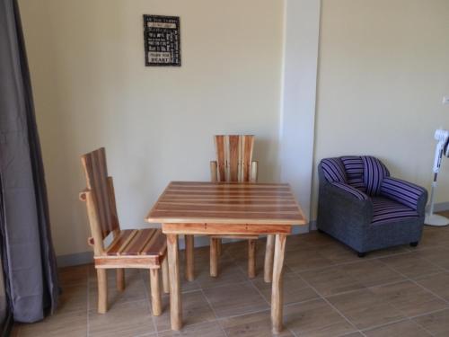 a wooden table and two chairs in a room at The Blue Pagong in Puerto Galera