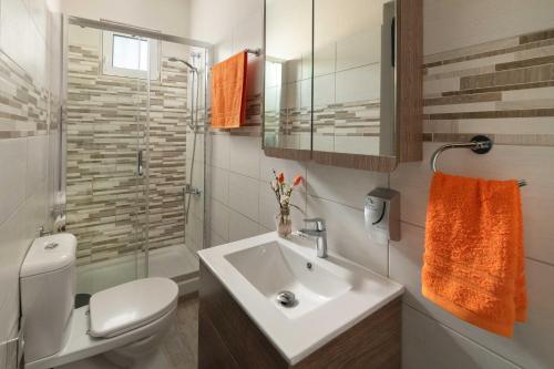 a bathroom with a white sink and a toilet at Sugar View Villa In Kolymbia in Kolymbia