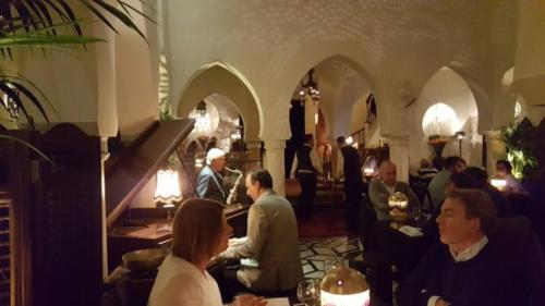 a group of people sitting at tables in a restaurant at luxury apartment in Marina Casablanca in Casablanca