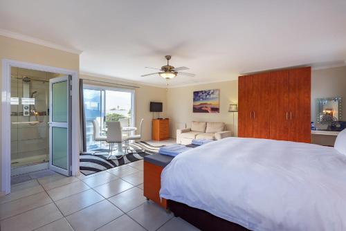 a bedroom with a bed and a living room at Pro Moni's Guesthouse in Muizenberg