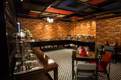 a restaurant with tables and chairs and a brick wall at Max Boutique Hotel in Cao Bằng