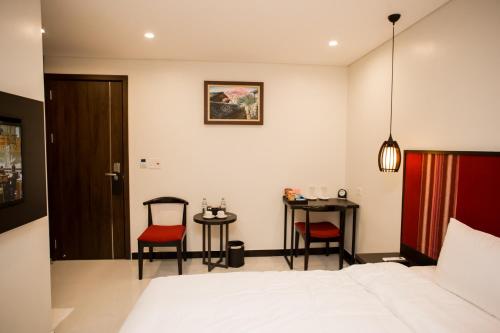 a bedroom with a bed and two chairs and a table at Max Boutique Hotel in Cao Bằng