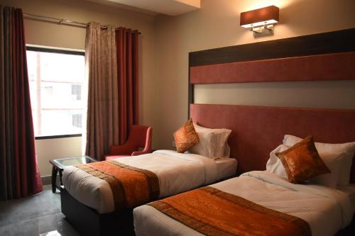 Hotel Abhinav International tesisinde bir odada yatak veya yataklar
