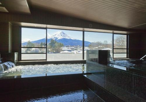 a swimming pool with a view of a snow covered mountain at Oike Hotel in Fujikawaguchiko