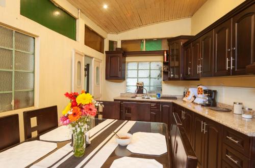 a kitchen with a vase of flowers on a table at Hotel Vintage "Casa las Flores" in Quetzaltenango