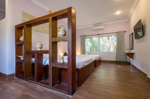a bedroom with a bed and a large mirror at Kep Bungalows in Kep