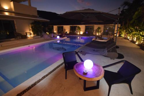 - une piscine avec une table et des chaises à côté d'une maison dans l'établissement AMAYA Resort, à Lamai