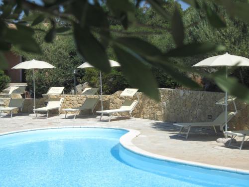 a swimming pool with lounge chairs and umbrellas at Hotel Belvedere in Teulada
