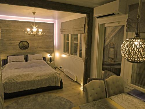 a bedroom with a bed and a chandelier at Apartments Huili in Tahkovuori