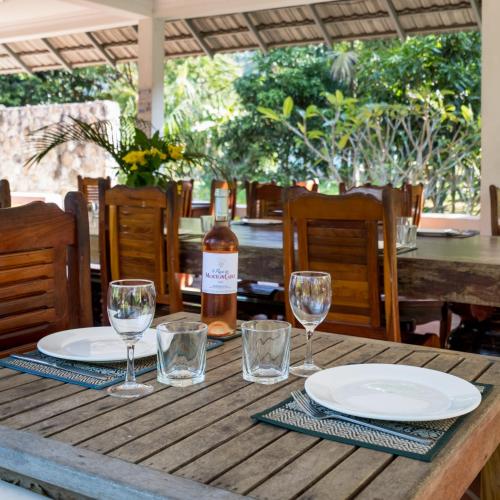 a wooden table with glasses and a bottle of wine at Kep Bungalows in Kep