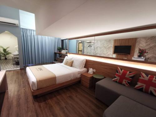 a bedroom with a large bed and a couch at Iconic Suites & Pods Hotel in Ipoh