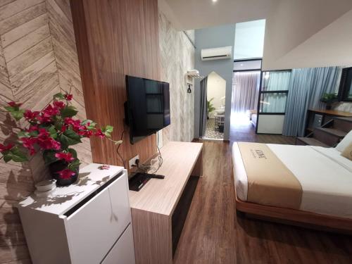 a hotel room with a bed and a television at Iconic Suites & Pods Hotel in Ipoh