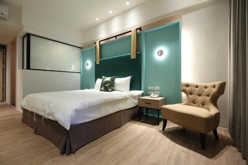 a bedroom with a large bed and a chair at Hai Sheng Wei B&B in Dahan