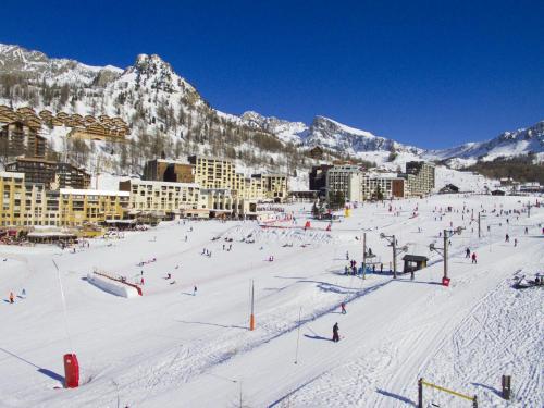 a group of people skiing down a snow covered slope at Chalet Pointu in Isola 2000