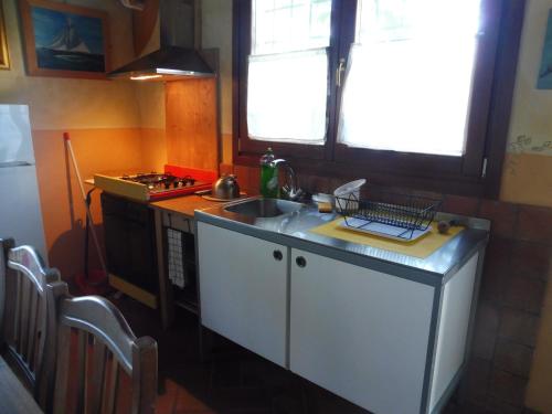 a small kitchen with a sink and a stove at Alle porte di Marano in Marano