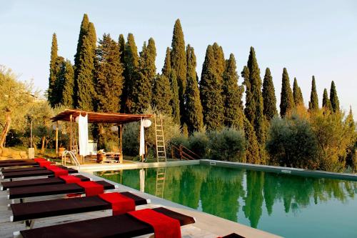 a pool with benches and a gazebo and trees at Settignano Tuscany Homes in Settignano