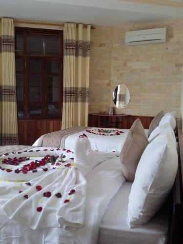 a bedroom with two beds with roses on them at Nam Phương Riverside Villa in Hue