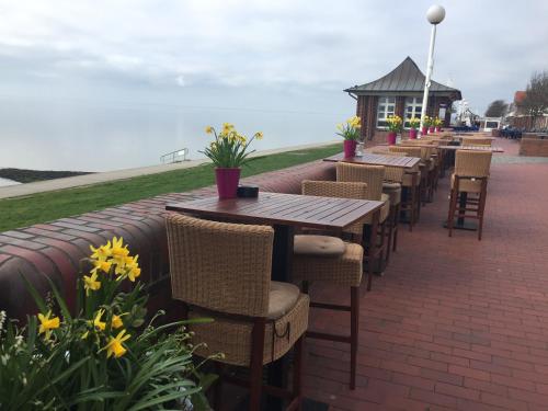 a row of tables and chairs on a brick patio at Strand-Hotel Seenelke in Wilhelmshaven