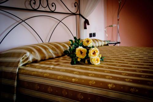 a bouquet of yellow roses sitting on a bed at Agriturismo Monbertola in Govone