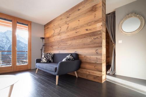 a room with a wooden wall with a chair and a mirror at Alp n' rose in Hasliberg