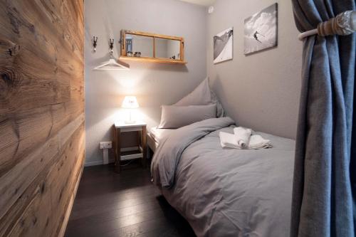 a bedroom with a bed and a table with a lamp at Alp n' rose in Hasliberg