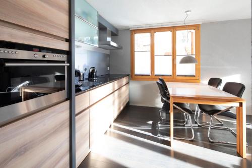 a kitchen with a wooden table and a dining room at Alp n' rose in Hasliberg