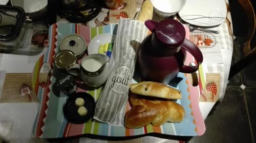 een tafel met een theepot en een gebakje bij Chez Marguerite Gîtes à la ferme in Horbourg