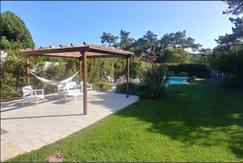 a gazebo with two chairs and a hammock in a yard at Casa Girassol with a beautiful private Pool and Garden in Sintra