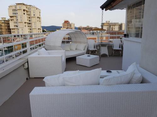 un balcone con divani e tavoli su un edificio di Hotel Bella 'Mbriana a Follonica