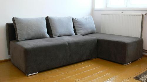 a grey couch sitting in a room with a window at Złota Leśniczówka in Rydzówka