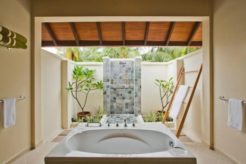 a bathroom with a tub, sink, and toilet at Kurumba Maldives in North Male Atoll
