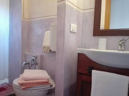 uma casa de banho com um lavatório e um WC com toalhas em La Torretta em Laterina