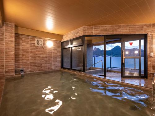 a room with a pool of water in a building at Central Hotel Takeoonsen Ekimae in Takeo