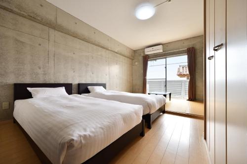 a bedroom with two beds and a large window at Hotel Resort Inn Ishigakijima in Ishigaki Island