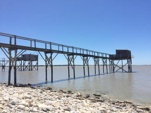 a pier in the water next to a beach at Boutique Hôtel d'Orbigny Chatelaillon - La Rochelle in Châtelaillon-Plage